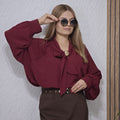 Bordowa bluzka damska elegancka z kokardą i złotą broszką luźny fason, bufiaste rękawy